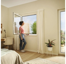 Dormitor luminos cu fereastră batantă și o femeie care se uită afară