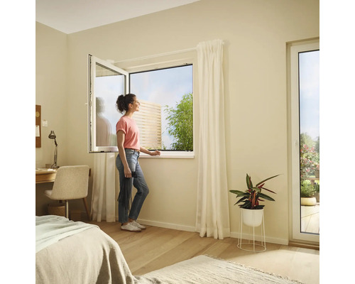 Dormitor luminos cu fereastră batantă și o femeie care se uită afară