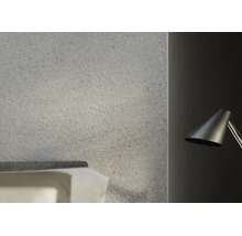 Decor de perete cu aspect de piatră și suprafață structurată într-un dormitor modern lângă o lampă de lectură.
