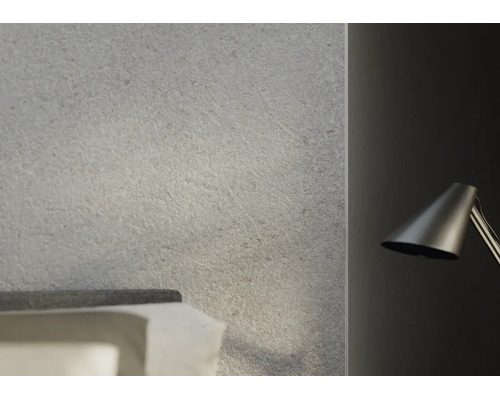 Decor de perete cu aspect de piatră și suprafață structurată într-un dormitor modern lângă o lampă de lectură.