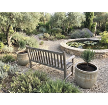 Scenă de grădină cu bancă de lemn, jardiniere și iaz