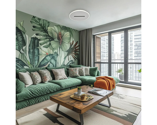 Sufragerie modernă cu canapea de colț verde, măsuță din lemn și fototapet botanic cu frunze mari. Atmosferă luminoasă.