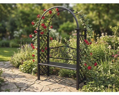 Bancă de grădină cu arcadă de trandafiri pe o alee de piatră într-o grădină.