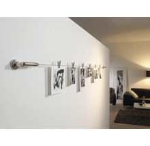 Fotografii pe o șină de perete cu cleme în camera de zi