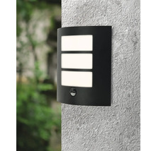 Lumină de perete neagră cu senzor de mișcare și trei ferestre de lumină dreptunghiulare pe un perete.