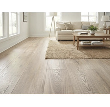 Cameră de zi cu podea din lemn deschis la culoare, canapea, covor și masă