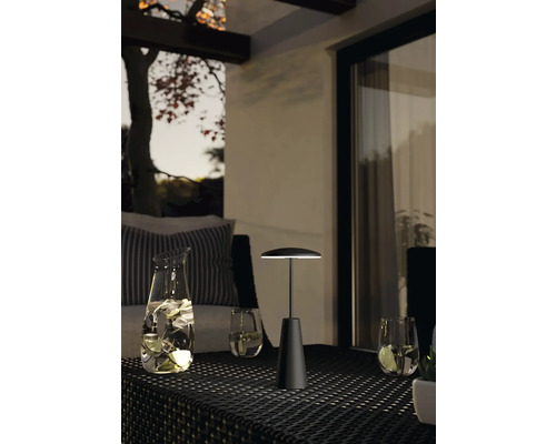 Lampă de masă pe o masă în aer liber cu băuturi și pahare.