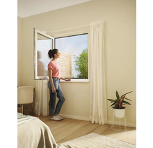 Femeie la fereastra deschisă cu plasă de țânțari în dormitor