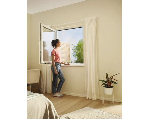 Femeie la fereastra deschisă cu plasă de țânțari în dormitor