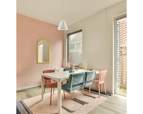 Zonă de luat masa luminoasă cu masă albă, scaune tip consolă din catifea albastră, pendulă albă și oglindă cu ramă galbenă.