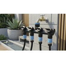 Scenă de grădină cu un distribuitor multiplu for.q pe robinetul de apă