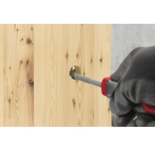 O scândură de lemn este prelucrată cu o raspă.