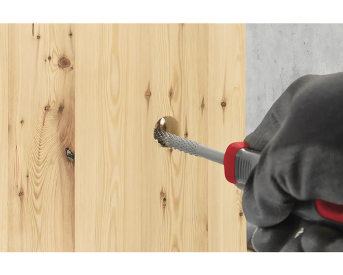 O scândură de lemn este prelucrată cu o raspă.