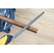 Țeavă de cupru în menghină cu pilă de metal