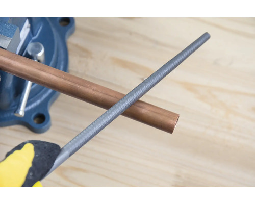 Țeavă de cupru în menghină cu pilă de metal