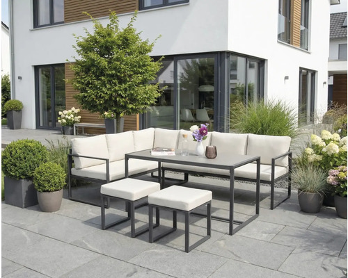 Set de mobilier de grădină cu bancă de colț, masă și taburete pe o terasă în fața unei case moderne