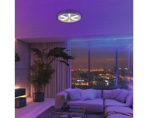 Sufragerie modernă cu ventilator de tavan cu lumină inclusă, canapea, fereastră mare cu vedere spre oraș și plante de interior.