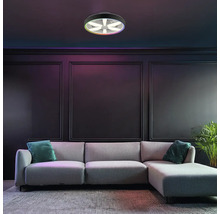 Plafonieră LED modernă cu ventilator și funcție de culoare RGB, montată într-o cameră de zi întunecată, cu o canapea gri și panouri de perete.