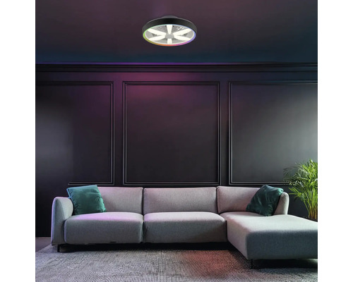 Plafonieră LED modernă cu ventilator și funcție de culoare RGB, montată într-o cameră de zi întunecată, cu o canapea gri și panouri de perete.