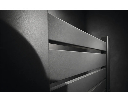 Vedere de aproape a unui radiator modern de baie de culoare antracit cu lamele plate orizontale și o suprafață mată texturată.