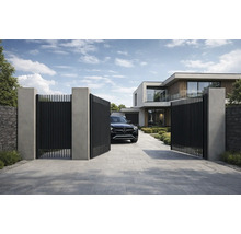 Poartă de acces modernă din lamele metalice negre între stâlpi de beton gri în fața unei case contemporane cu alee pavată.