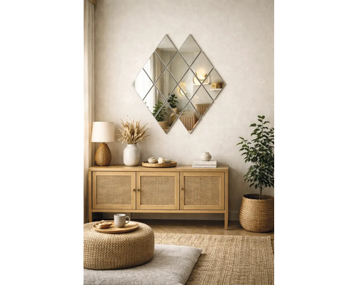 Living modern cu o oglindă de perete în formă de romb deasupra unei comode din lemn cu uși din ratan și decorațiuni naturale.