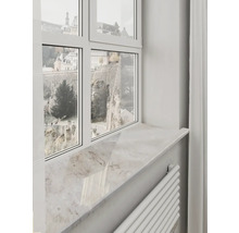 Pervaz de fereastră deschis la culoare cu aspect de piatră naturală sub o ramă de fereastră albă cu vedere spre ziduri istorice.