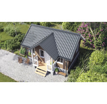 Căsuță de grădină din lemn cu acoperiș gri în două ape, ușă și ferestre albe și verandă într-o grădină cu alee cu pietriș.