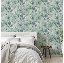 Dormitor modern, luminos, cu tapet vlies cu model floral în stil acuarelă, un pat și o măsuță din lemn.