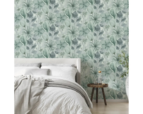 Dormitor modern, luminos, cu tapet vlies cu model floral în stil acuarelă, un pat și o măsuță din lemn.