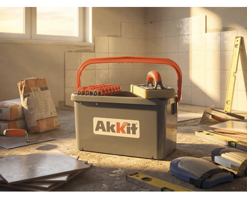 Set AkKit pentru curățat gresie și faianță cu găleată, role și driscă cu burete pe un șantier cu plăci ceramice și unelte.