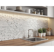 Bucătărie cu un perete de protecție din mozaic alb cu aspect de cărămidă și textură de marmură, blat din lemn, chiuvetă din inox și iluminat LED.