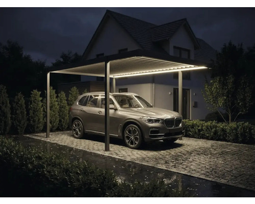 Carport modern din aluminiu cu iluminare LED integrată, acoperiș cu lamele și SUV parcat pe o alee pavată pe timp de noapte.
