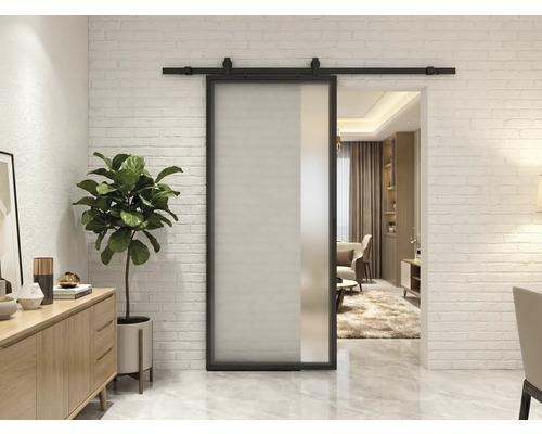 Ușă glisantă modernă din sticlă mată cu cadru și șină din metal negru pe un perete din cărămidă albă.