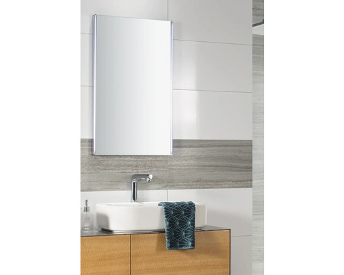 Baie luminoasă cu dulap cu oglindă modern cu iluminare LED, lavoar pe blat alb și un dulap de bază cu aspect de lemn.