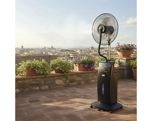Ventilator cu picior negru cu funcție de pulverizare pe o terasă cu plante și vedere panoramică asupra orașului.