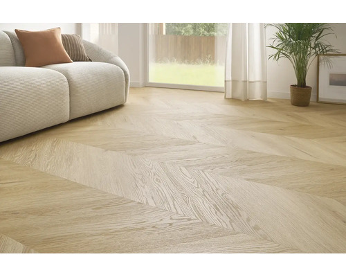 Sufragerie luminoasă cu pardoseală cu aspect de lemn cu model chevron, canapea modernă și plantă de interior în fața unei ferestre.