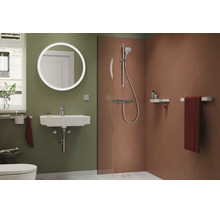 Baie modernă cu oglindă LED rotundă, chiuvetă albă, duș de tip walk-in cu plăci ceramice teracota și pereți verzi.