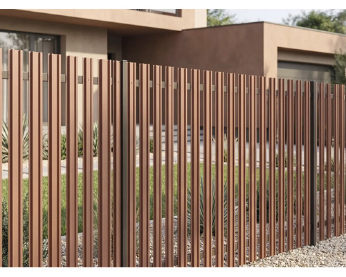 Gard de grădină modern din lamele verticale cu aspect de lemn în fața unei case cu grădină și strat de pietriș.