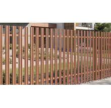 Gard modern de grădină din lamele metalice verticale în fața unei case cu un pat de pietriș, gazon și plante.