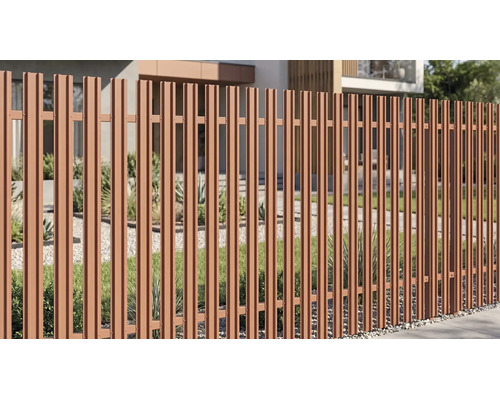 Gard modern de grădină din lamele metalice verticale în fața unei case cu un pat de pietriș, gazon și plante.
