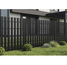 Gard modern de grădină din lamele verticale negre pe o peluză în fața unei case.