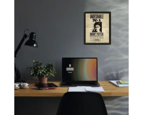 Poster înrămat Harry Potter Undesirable numărul 1 pe un perete gri deasupra unui birou din lemn organizat cu laptop și lampă.