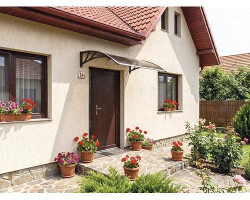 Copertină modernă pentru ușa de la intrare în formă de arc, deasupra unei uși maro pe o fațadă deschisă cu decorațiuni florale.