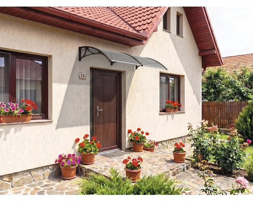 Copertină de intrare curbată modernă în gri închis deasupra unei uși de intrare maro la o casă luminoasă cu flori.