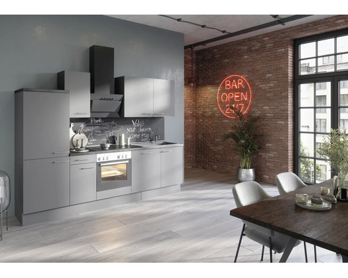 Bucătărie modernă gri în stil loft cu aparate electrocasnice în fața unui perete de cărămidă cu semn luminos și o masă de dining.