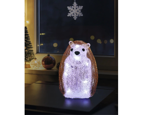 Figurină decorativă LED arici din acril cu suprafață cristalină, așezată pe o masă într-o cameră decorată festiv pentru Crăciun.