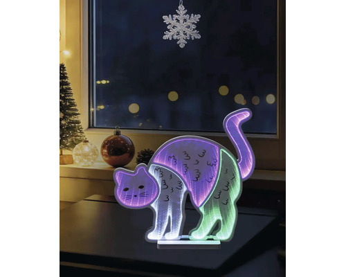 Figurină decorativă LED pisică cu efect de oglindă infinită și lumini multicolore, plasată într-un decor de Crăciun în fața unei ferestre.