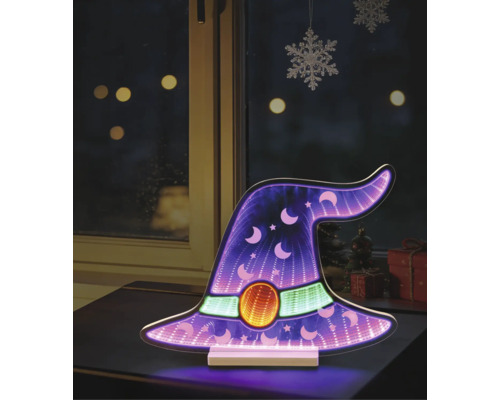 Decorațiune LED pălărie de vrăjitoare cu efect de oglindă infinită, stele și luni pe o masă în fața unei ferestre.