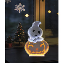 Decorațiune de Halloween cu LED fantomă pe dovleac cu efect de oglindă infinită în fața unei ferestre lângă un brad de Crăciun împodobit.